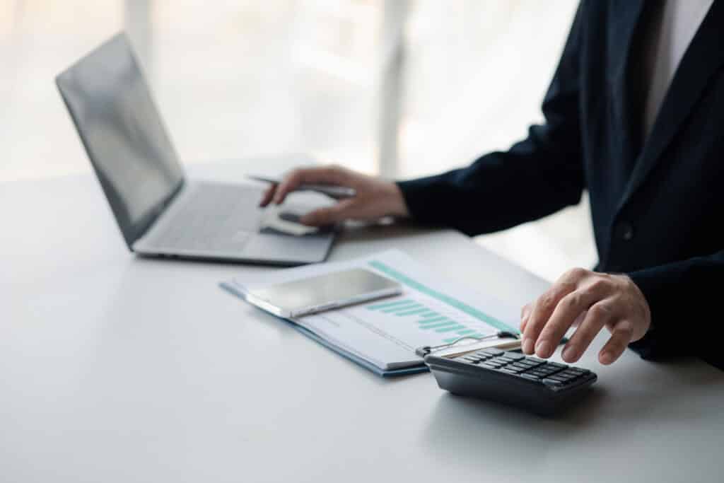 business man using a calculator to calculate numbers on a compan